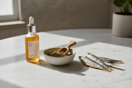 Salmon oil bottle, green lipped mussel powder and dried sardines arranged on a marble surface as omega-3 supplement options for pets